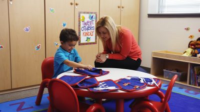 Can you walk a mile in my shoes - Teacher shows child how to use Manual Dexterity Boards